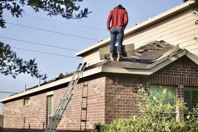 Professional roofer working on a residential roof in Scribner
